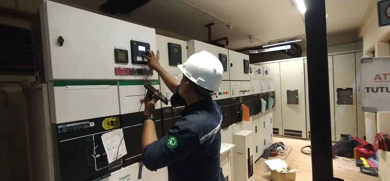 Engineer configuring a switchgear control panel